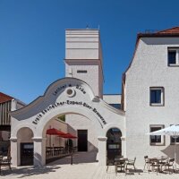 Das sanierte Baudenkmal wird von der Sonne angestrahlt und die Eisdiele hat Stühle und Tische rausgestellt.  © Gerhard Hagen